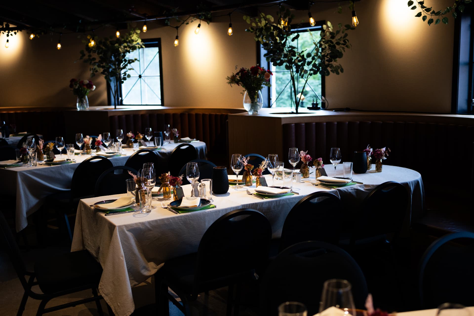 Dekket langbord med blomster og lyslenker i Rondos selskapslokale